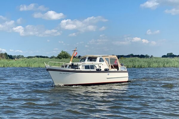 Motorboot op vaarvakantie in Friesland, met riet op achtergrond 